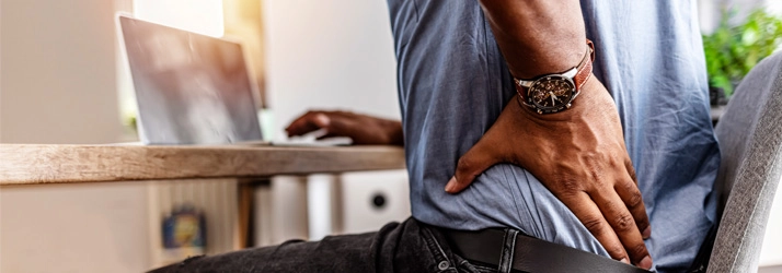 Chiropractic Gilbert AZ Back Pain A person holding their lower back.