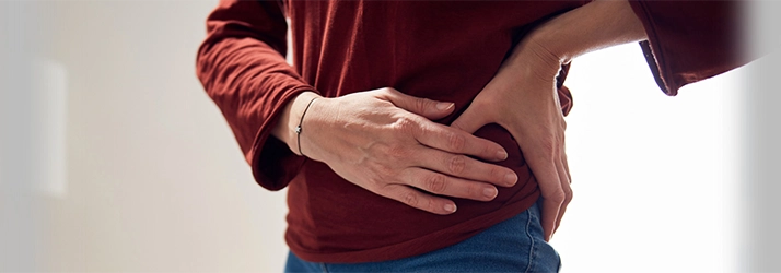 Chiropractic Gilbert AZ Side Pain A person holding their hip in pain.