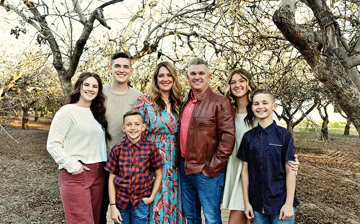 Chiropractor David Campbell smiling outside with his family.